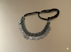 Handcrafted oxidised silver coin neckpiece with adjustable thread tie on golden background
