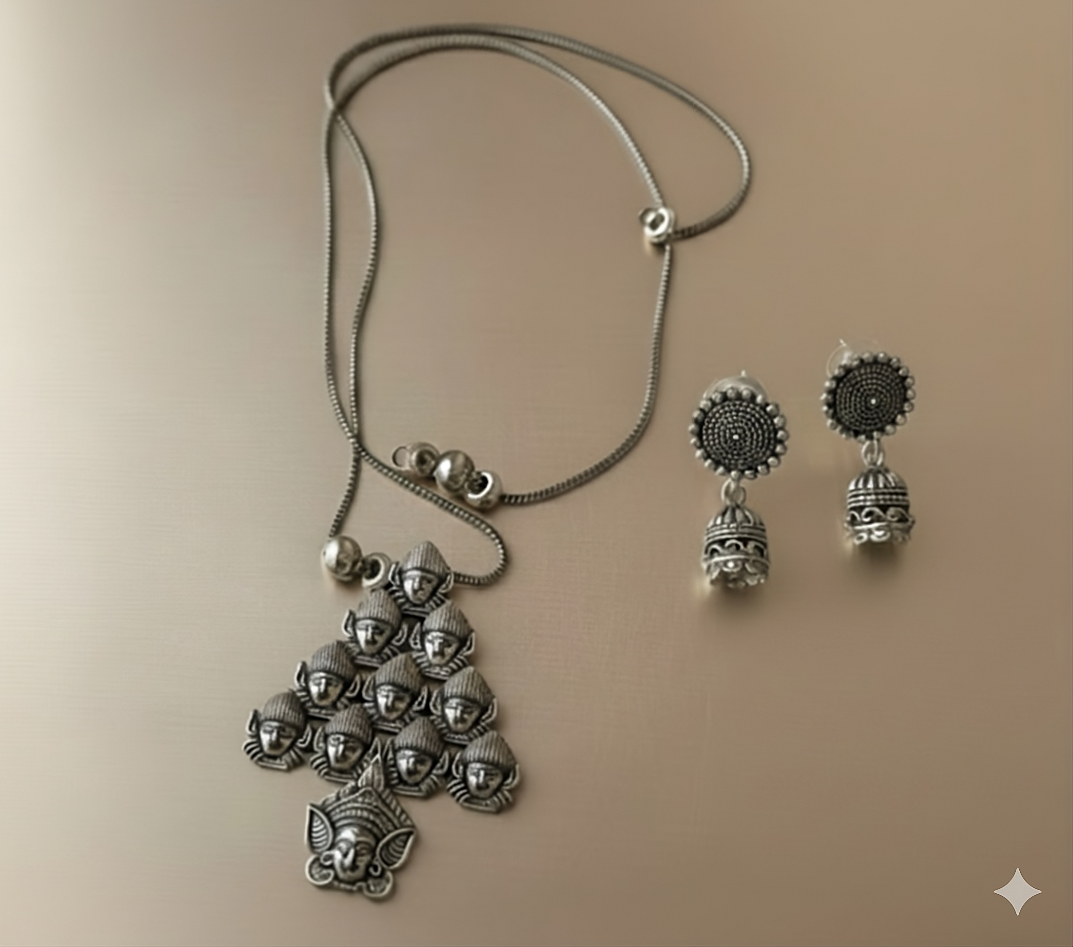 Handcrafted oxidised silver deity pendant neckpiece with bead-accented chain on golden background
